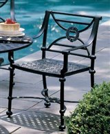 Shown in lead patina, the cast aluminum Peninsula chair is also available in antique driftwood (a rich brown) and textured black. The dining chair with woven seat is quite comfortable, requiring no cu